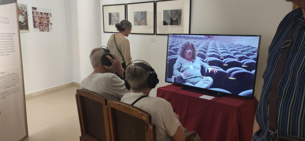 Persones escoltant un audio a l'exposició
