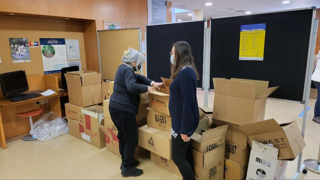 dos voluntaries a la Casa de Cultura fent caixes amb el material recollit