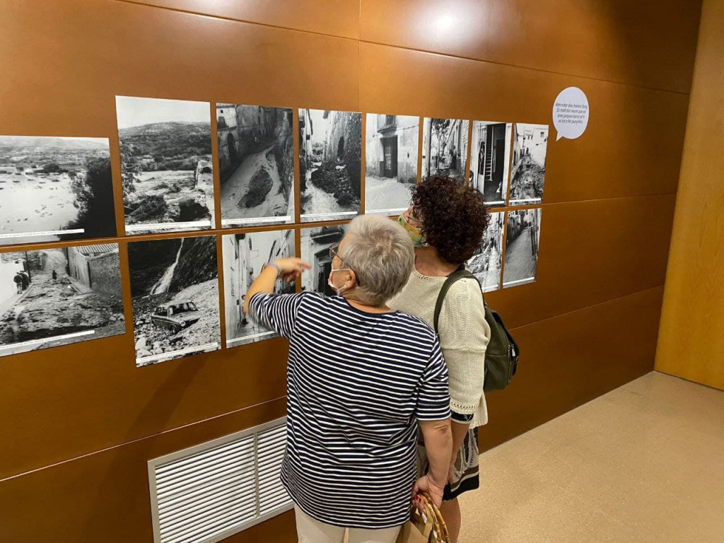 Dues persones mirant l'exposició de fotografies dels aiguats de 1971