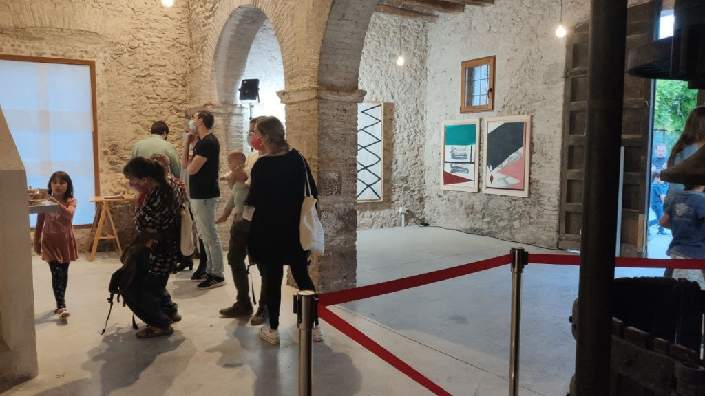 Persones amb nens visitant l'exposició a Cal Puigjaner
