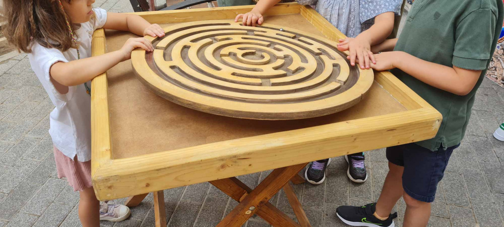 Nens jugant al joc gegant del laberint de fusta 